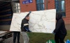 Грузчики Мегавоз бай заносят широкоформатную плитку из машины в квартиру физического лица